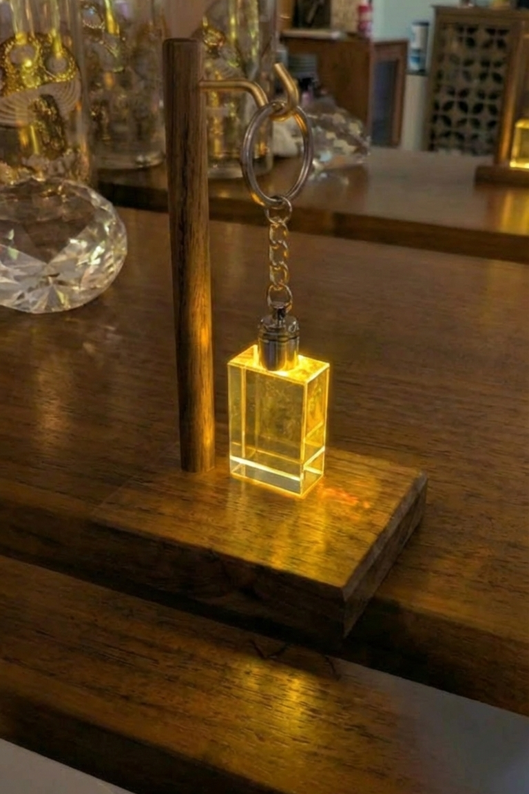 Keychain with a glowing square pendant on a wooden surface